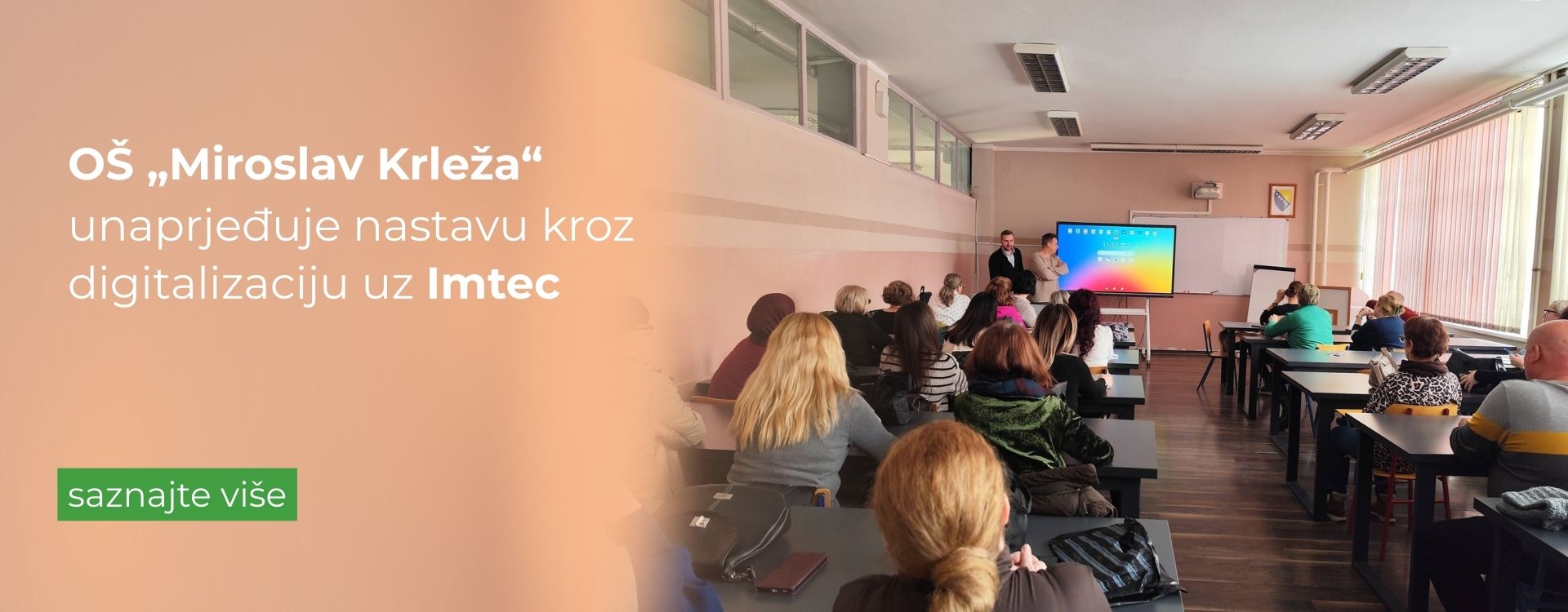 edukator stoji ispred interaktivnog ekrana i drži edukaciju nastavnicima osnovne škole